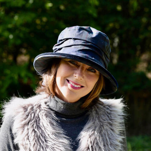 https://us.rainhatcollection.com/cdn/shop/products/peak-and-brim-bonnie-navy-waterproof-hat-on-woman_800x.jpg?v=1704912945